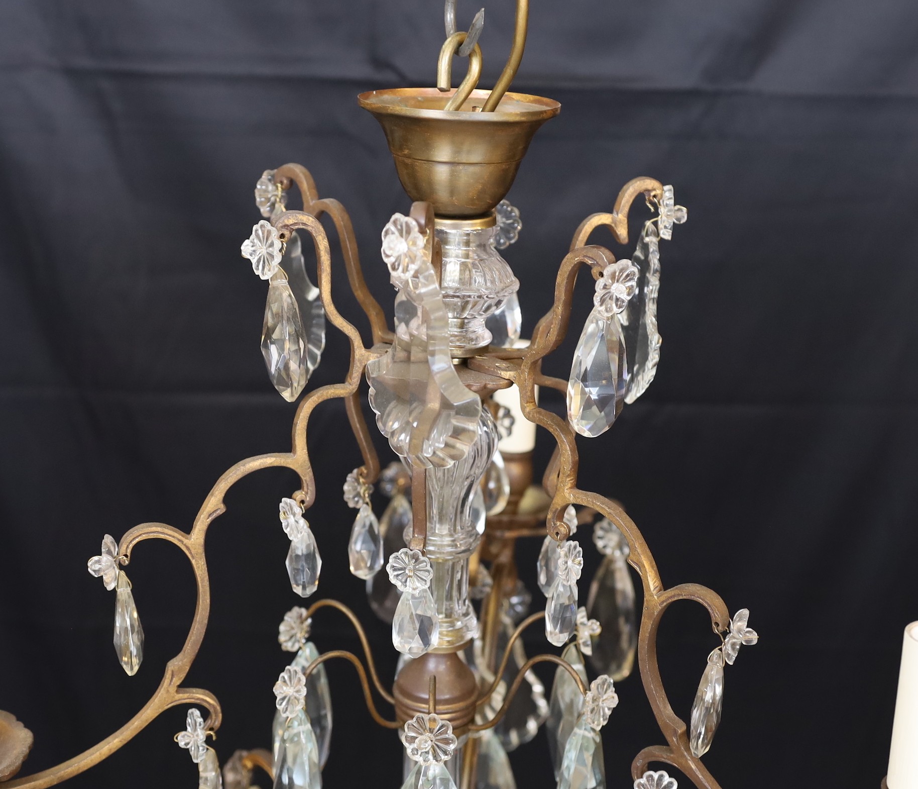 An early 20th century French bronze and cut glass three light chandelier, hung with tear shaped and faceted drops, height 64cm. width 50cm